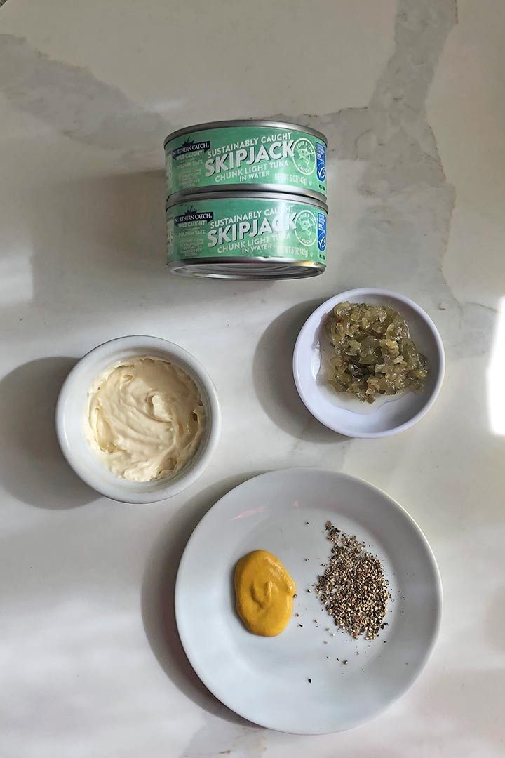 Ingredients to make recipe, mayonnaise, mustard, pepper, and cans tuna. 