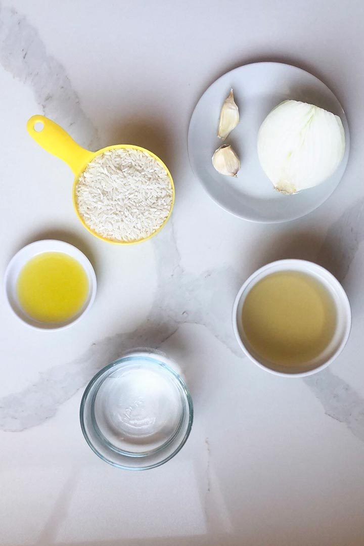 Ingredients to make traditional rice recipe on white surface.