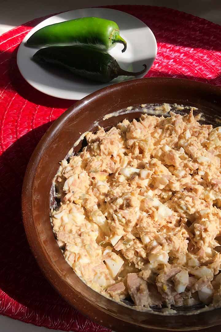 The Best Classic Tuna Salad with Eggs plated on a brown round bowl on Mexican pink surface.