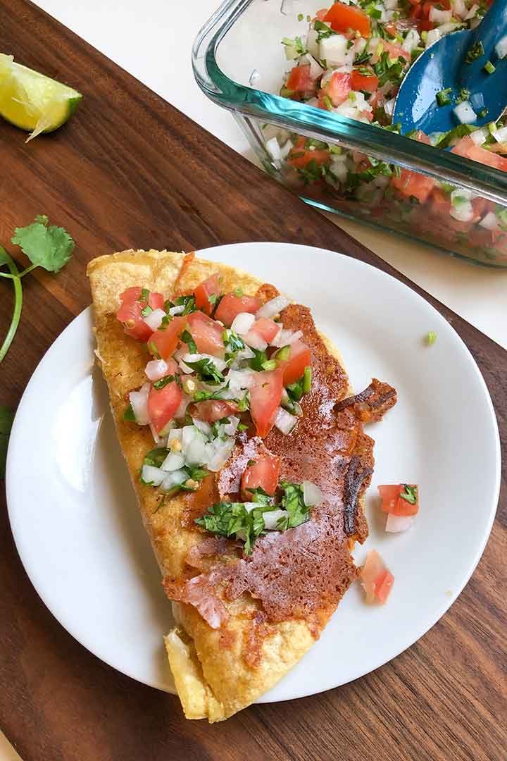 pico de gallo spooned ontop of a grilled cheese quesadilla.