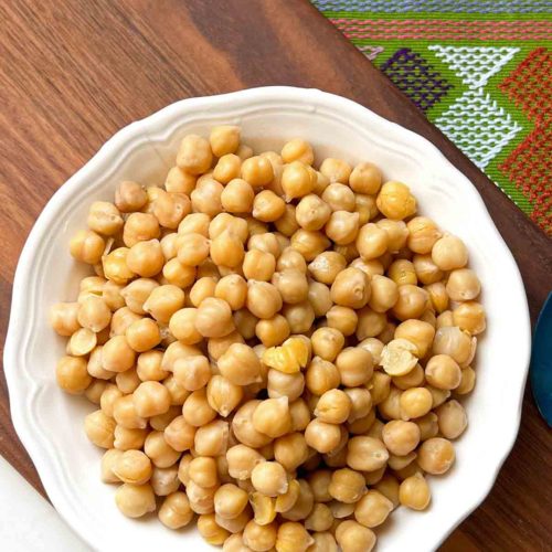 Cooked Instant Pot Chickpeas in a bowl on top of a brown surface.
