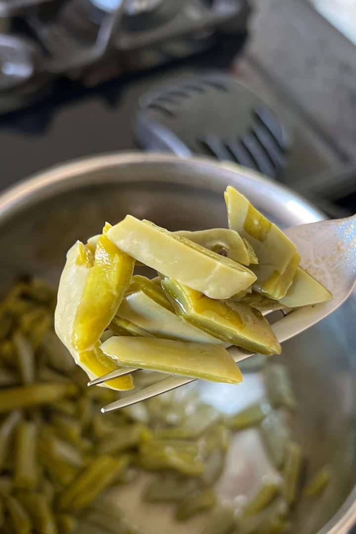 cooked tender nopales ingredient raised on fork.