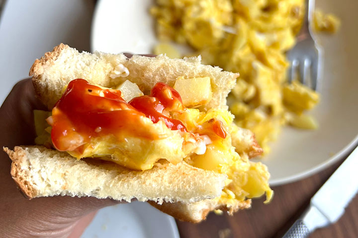 Breakfast sandwich made from Papas con Huevo recipe topped with ketchup.