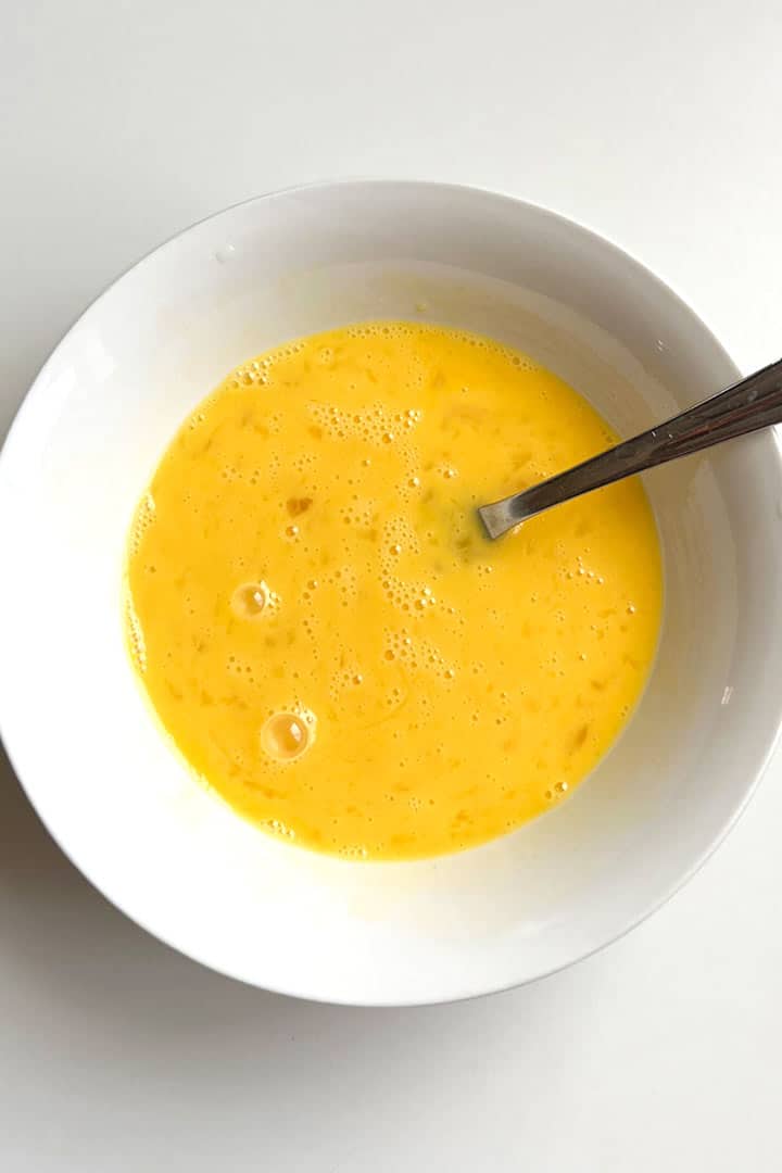 whisked eggs in a round bowl.