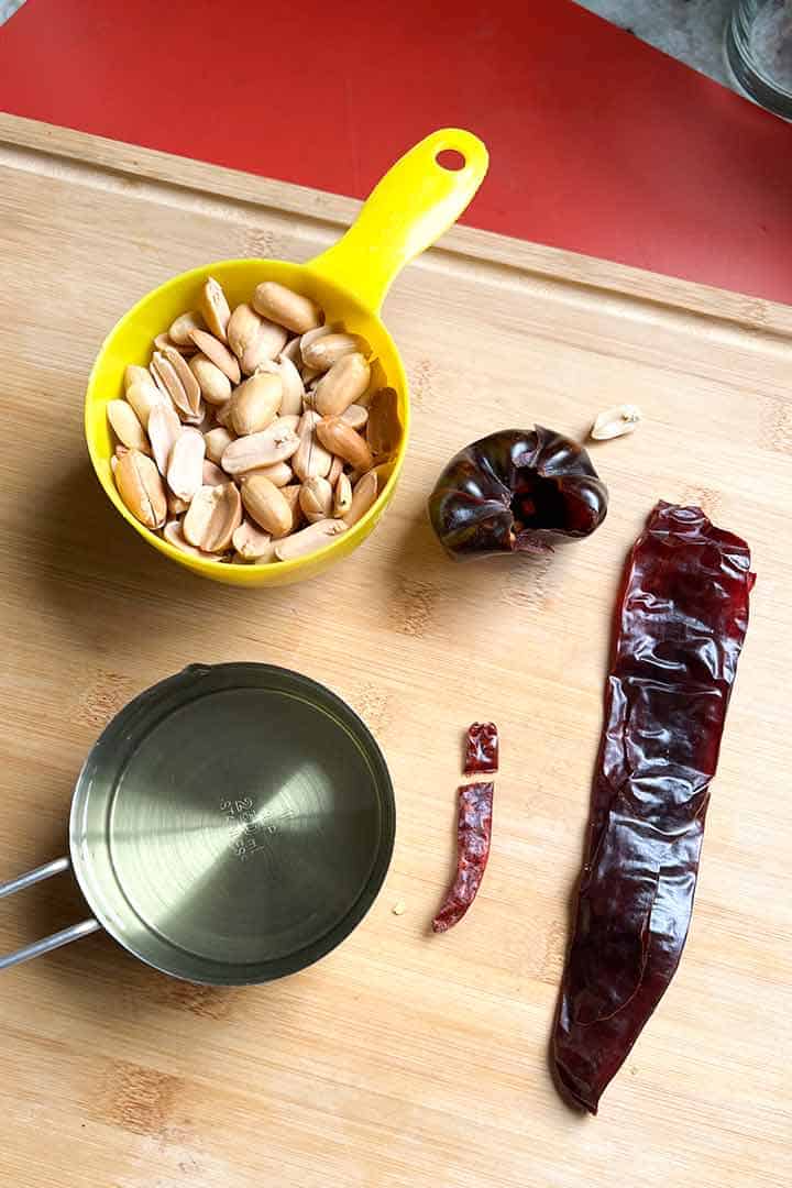Ingredients to make Cacahuate Salsa on a wood surface.