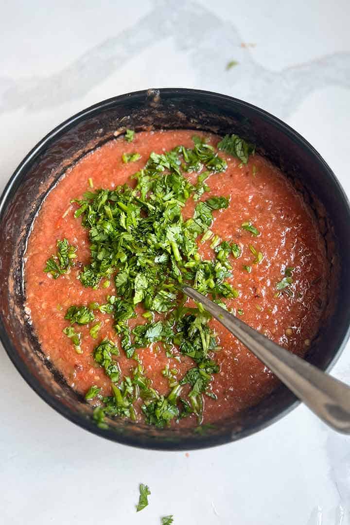 Salsa Ranchera with fresh chopped Cilantro in a bowl.