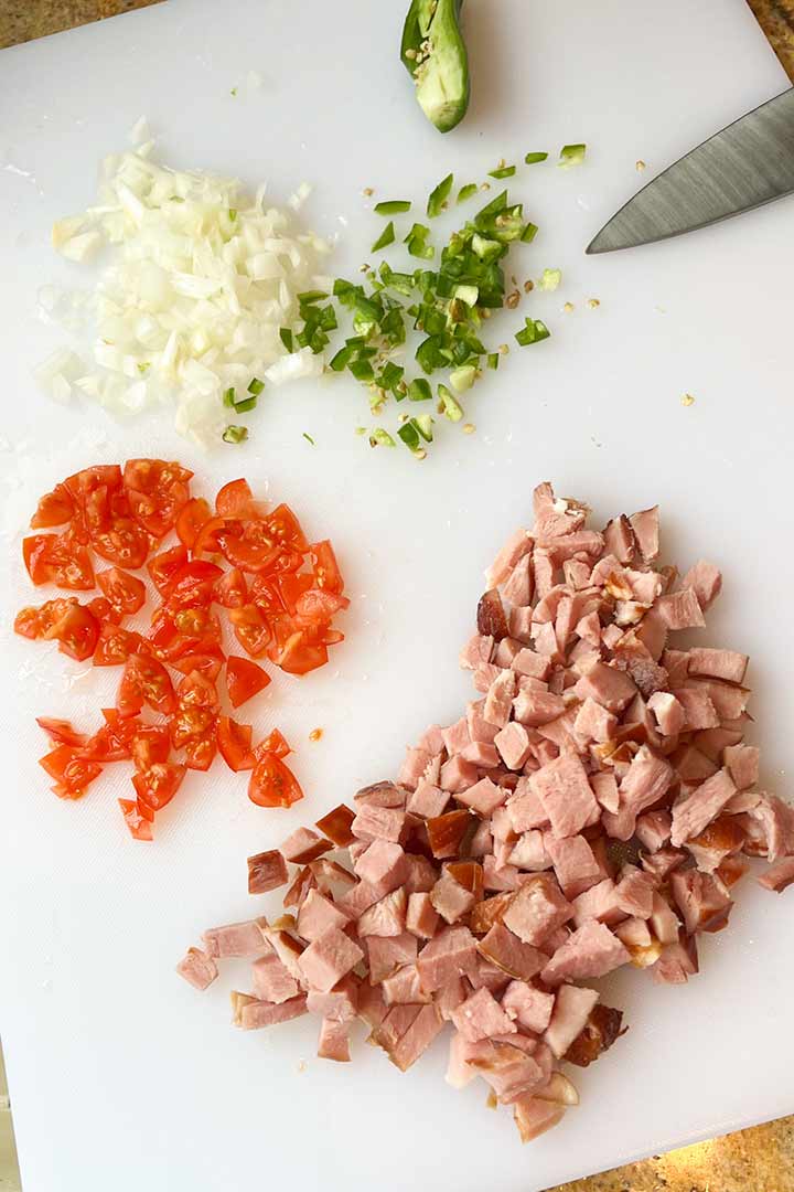 ingredients for breakfast scramble; eggs, cubed ham, onion, serrano pepper.