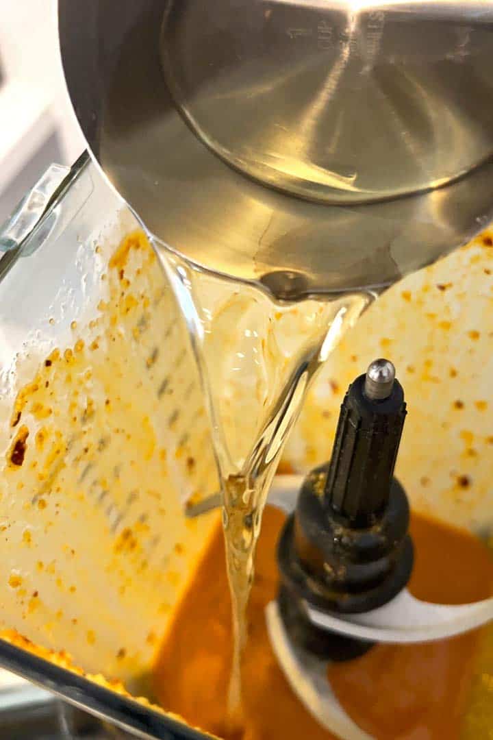 Adding second half of oil to the blender for last processing step.