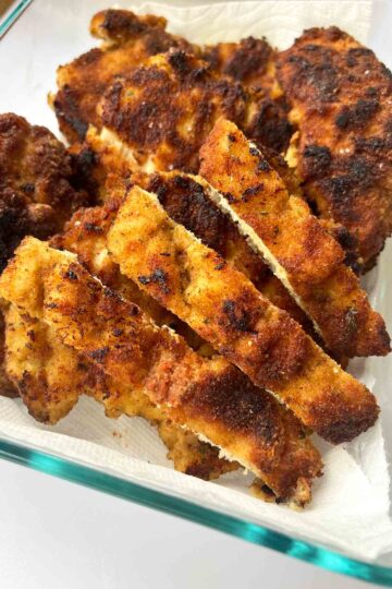 Chicken Milanesa recipe in glass kitchen storage.