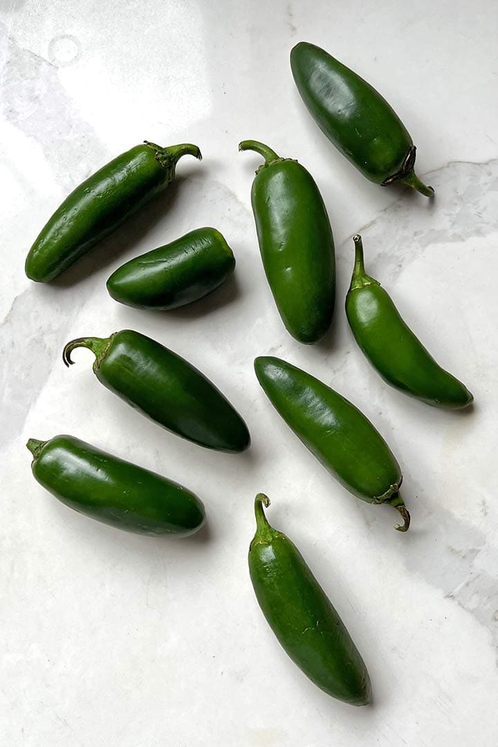 Main Ingredient to make blistered peppers on a white kitchen counter.