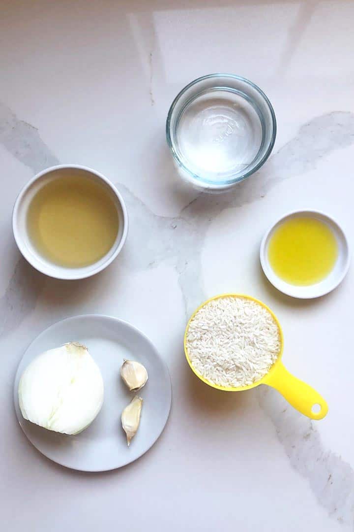 Ingredients for making Cotija Cheese Rice on a white kitchen surface.