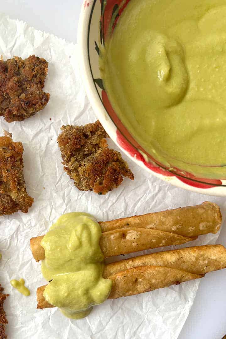 Jalapeno-sauce-served-over-rolled-chicken-taquitos-and-milanesa-tenders.