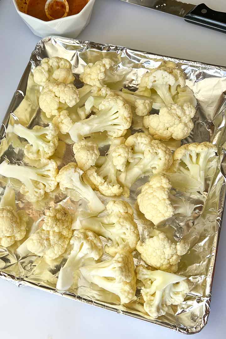 Raw-cauliflower-florets-spread-out-on-baking-tray.