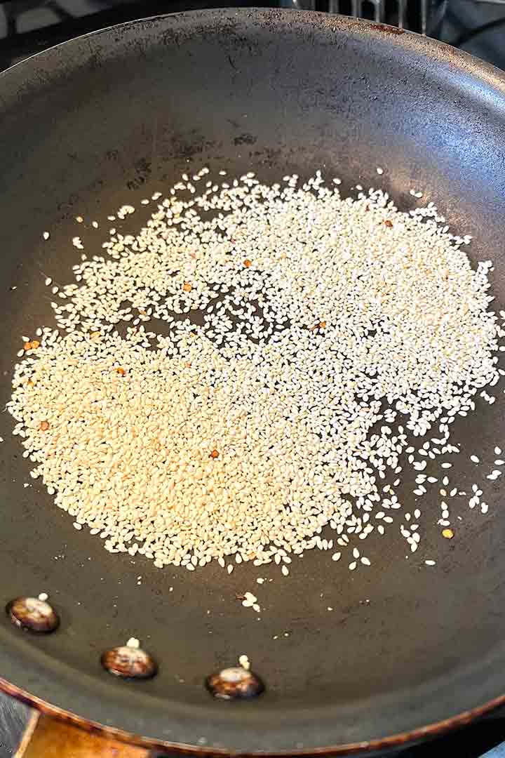 sesame seeds toasted in a pan on the stove.