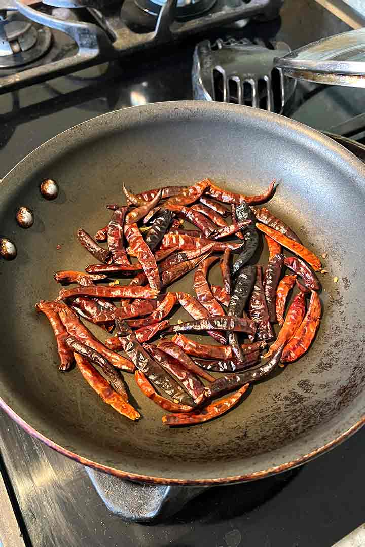 Roasting dried chili step in a pan on the stove.
