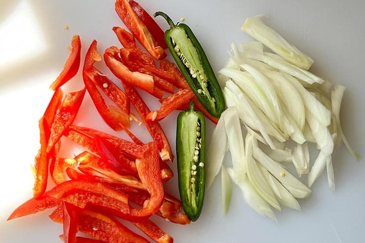 Ingredients for Mexican hot dogs with fresh red bell pepper, jalapeño, and onions