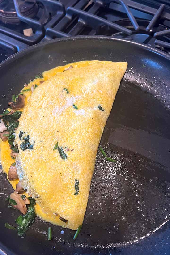 Once egg has cooked, fold light half over to close the cooked omelette.