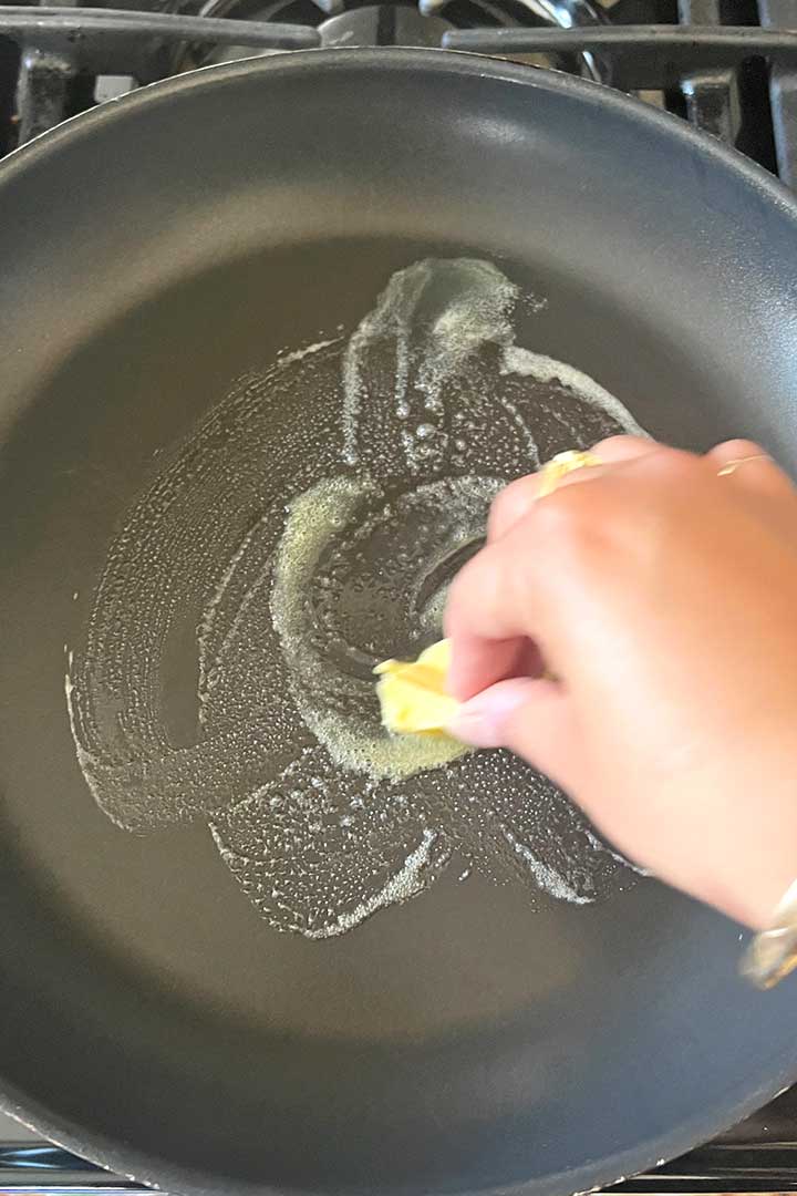 melting butter by rubbing it onto the hot pan by hand.